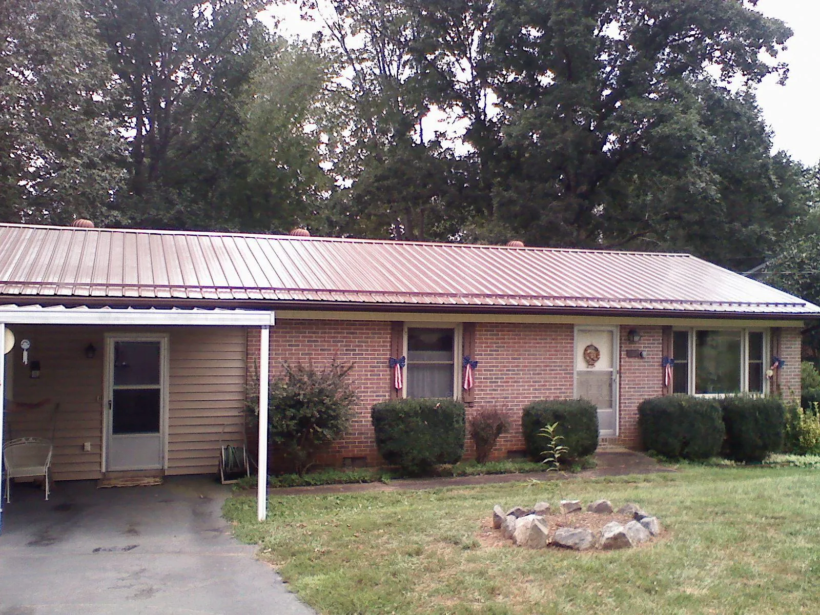 Bronze metal roof and carport on a brick ranch home — Roof Repair work by our crew in Vinton